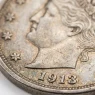 Close-up of a 1913 silver dollar highlighting engraving detail and patina